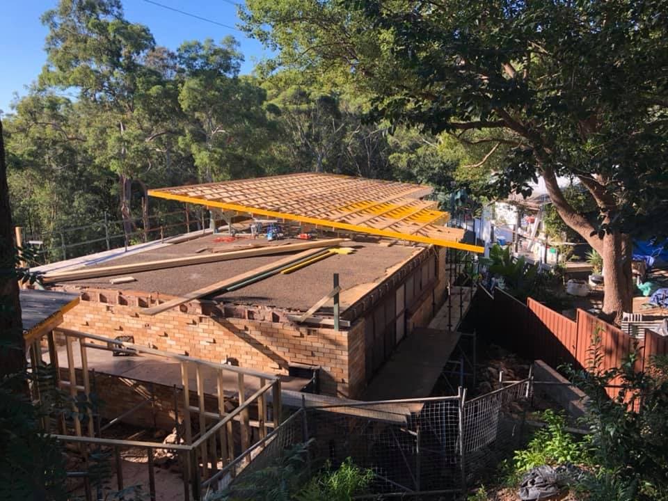 Framed roof panel being positioned over the extension, roof deck laid and edge-protected