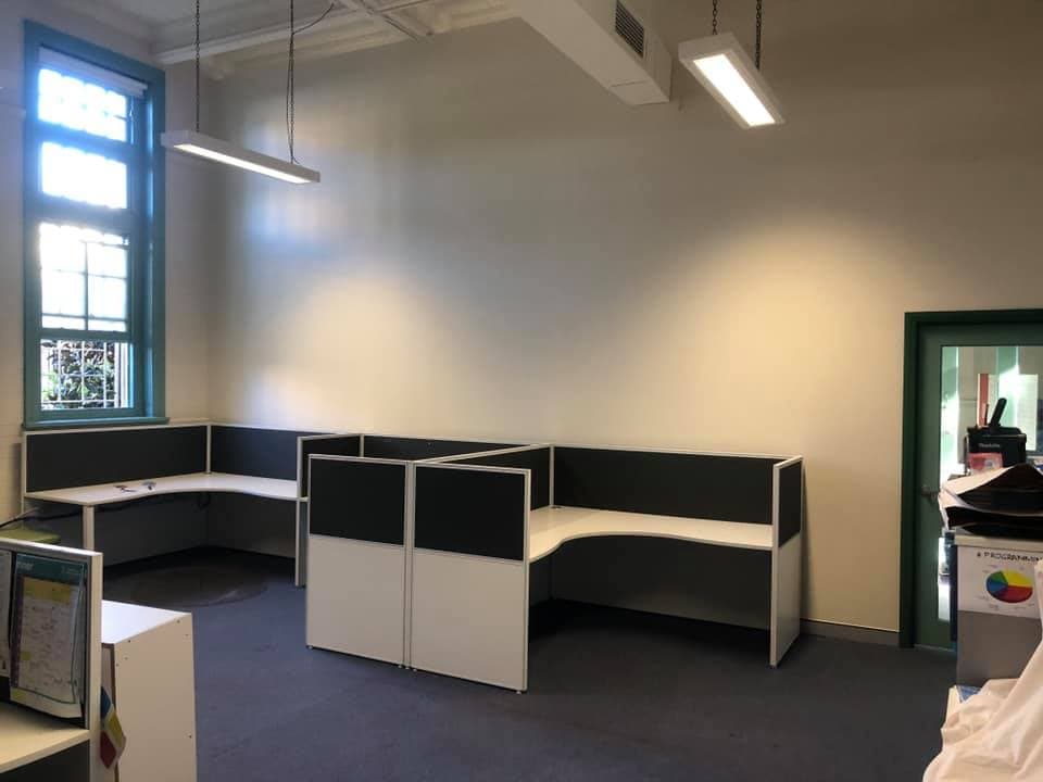 Office workstations fitted into a heritage building, working around original timber sash windows and painted joinery